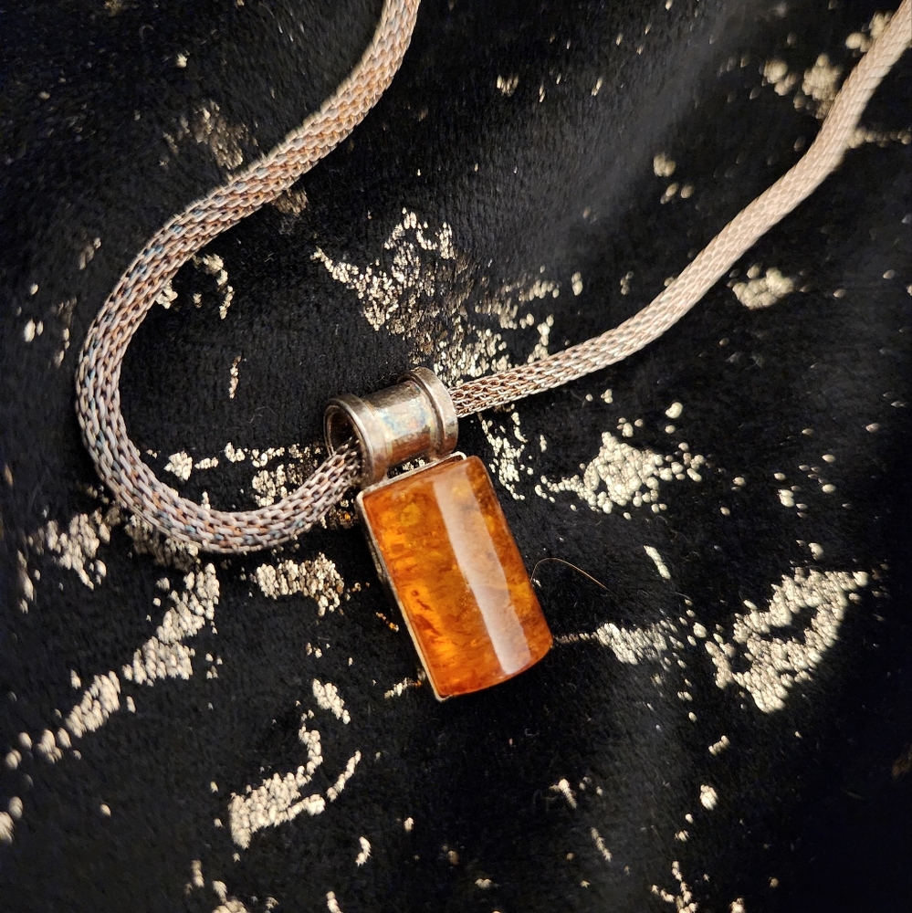 Silver pendant with amber.